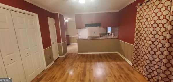 a kitchen with a refrigerator and wooden floor