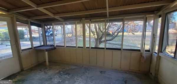 an empty room with windows and fan