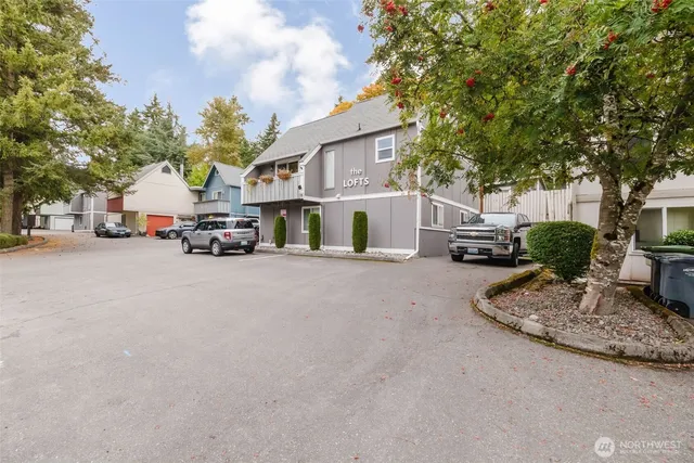 a view of road with card parked on side and retail shops
