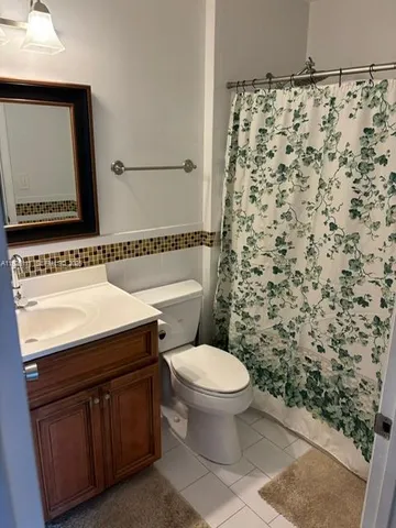a bathroom with a sink toilet and mirror