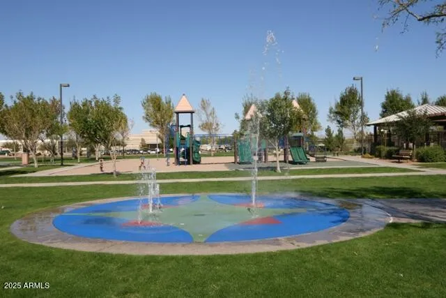 a view of a fountain in front of a building with palm trees