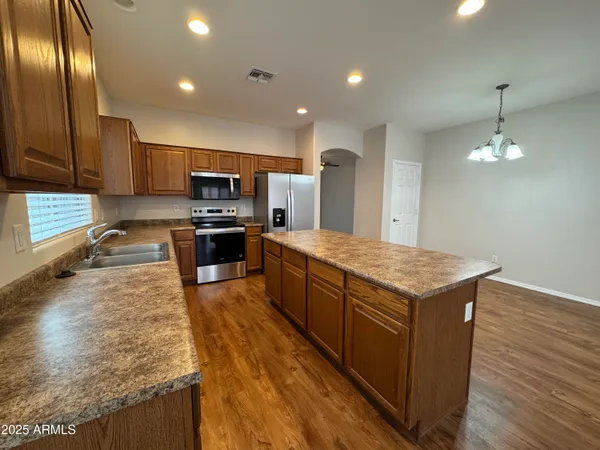 a large kitchen with stainless steel appliances granite countertop wooden cabinets a granite counter tops and a stove