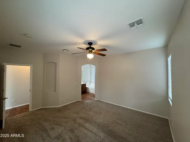 an empty room with closet and a chandelier fan