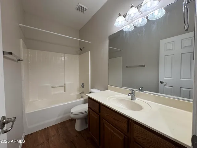 a bathroom with a sink a toilet a mirror and shower