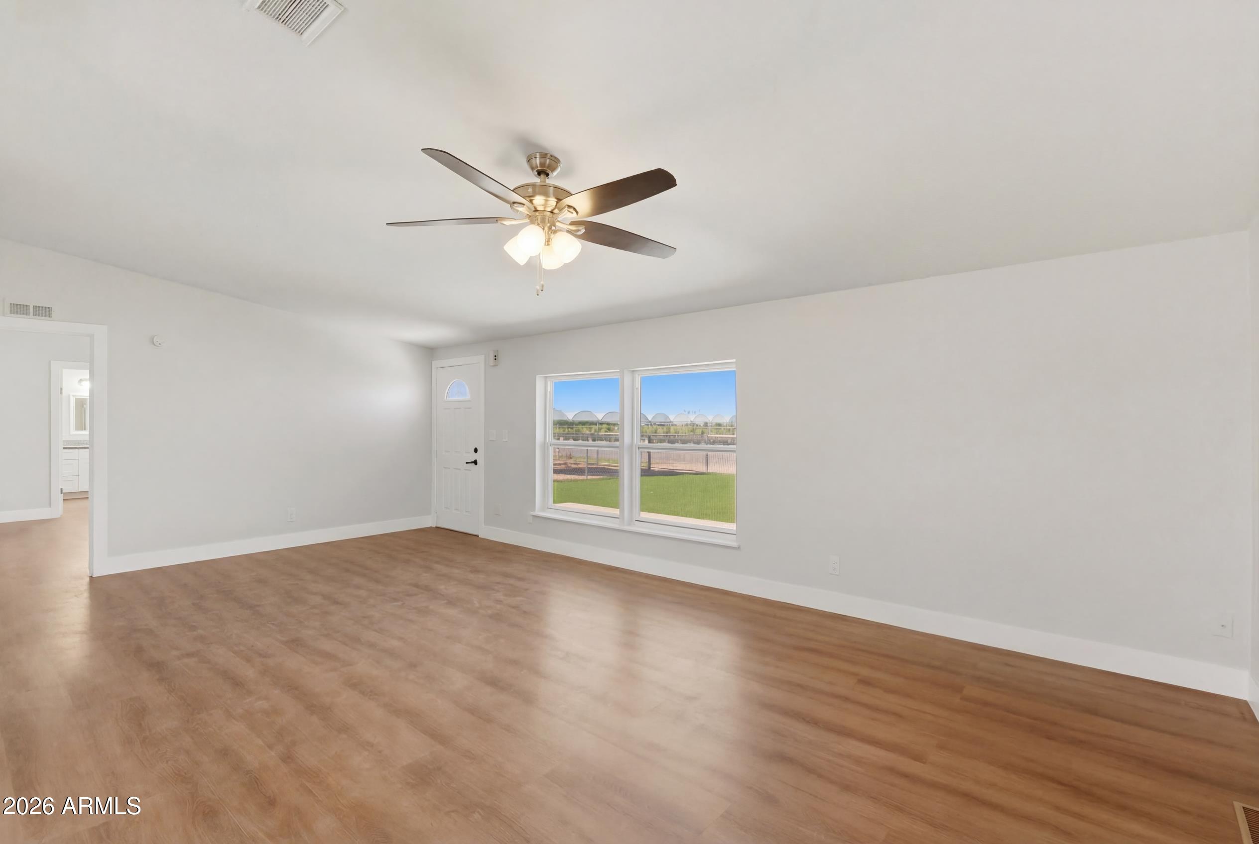 23317 South 180th Street Gilbert, AZ 85298 - Photo 22 of 36 an empty room with wooden floor fan and windows