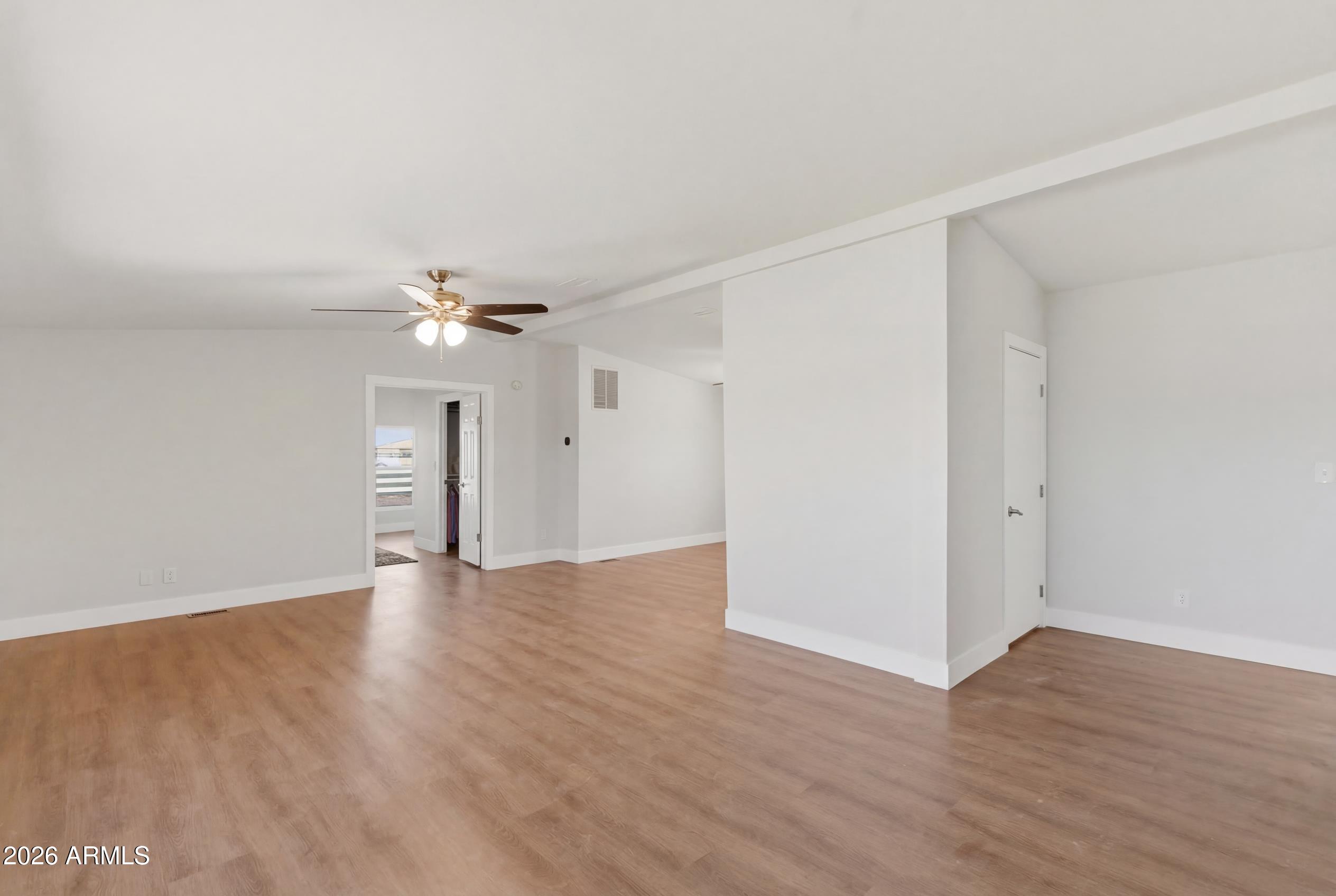 23317 South 180th Street Gilbert, AZ 85298 - Photo 23 of 36 an empty room with wooden floor ceiling fan and windows