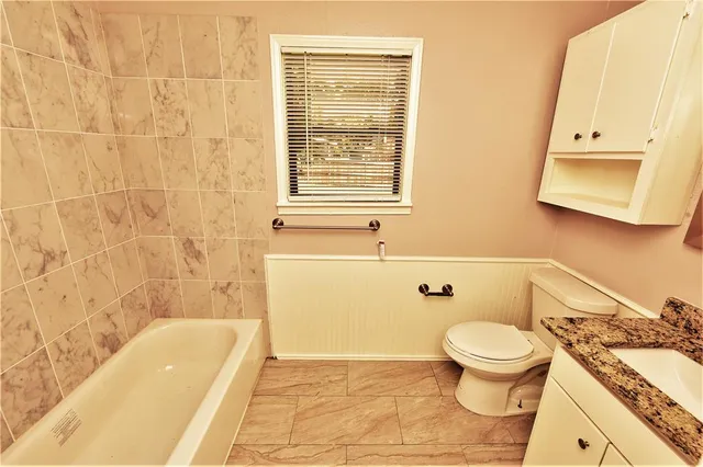 a bathroom with a toilet a sink and bathtub