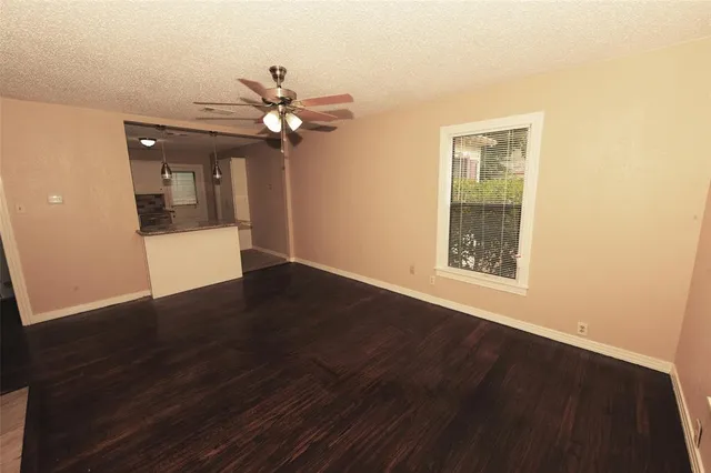 a view of a livingroom with a fan a ceiling fan and wooden floor