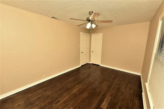 a view of a room with wooden floor and fan