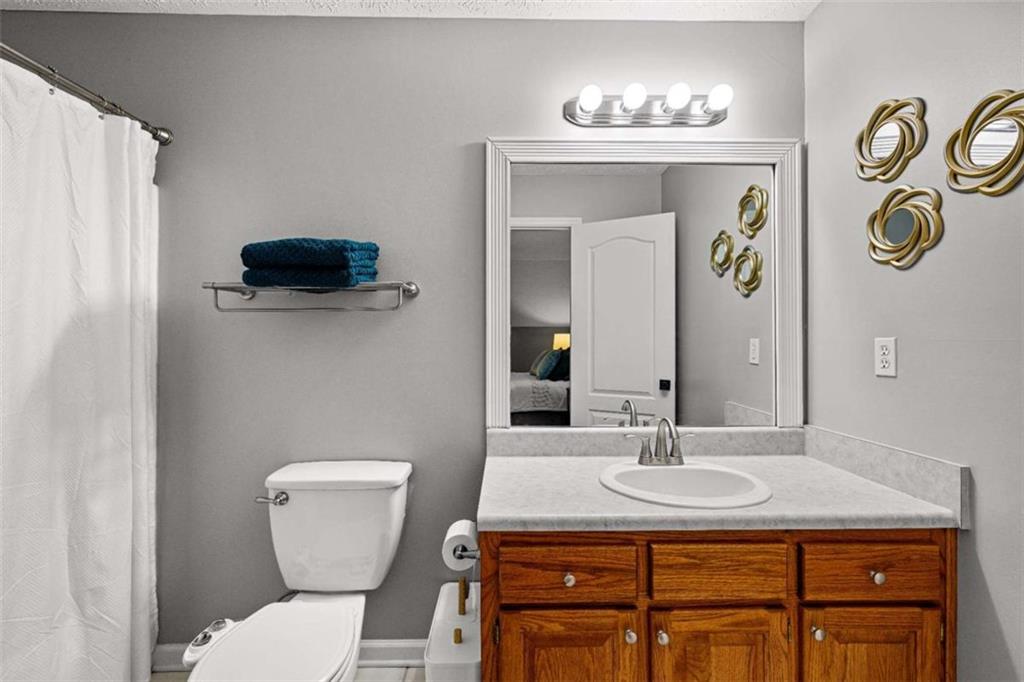 128 Byrom Road Senoia, GA 30276 - Photo 36 of 83 a bathroom with a granite countertop toilet sink and mirror
