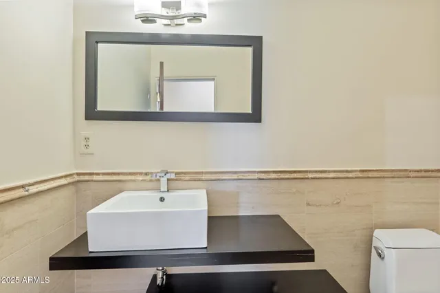 a bathroom with a sink a mirror and toilet