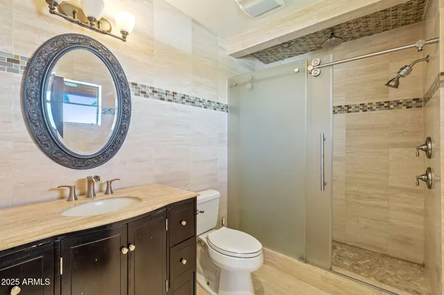 a bathroom with a granite countertop sink a mirror and a toilet