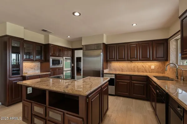 a kitchen with stainless steel appliances granite countertop a sink stove and refrigerator