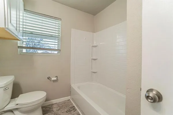 a bath room with a toilet and a bath tub