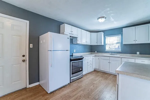 a kitchen with a refrigerator stove and wooden cabinets
