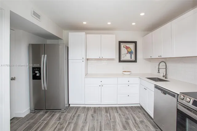 a view of a kitchen with sink cabinets and wooden floor