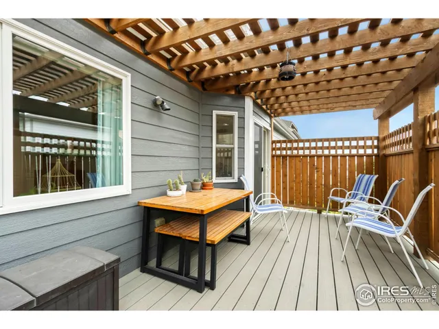 a balcony with wooden floor table and chairs