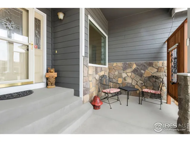 a balcony with table and chairs and potted plants