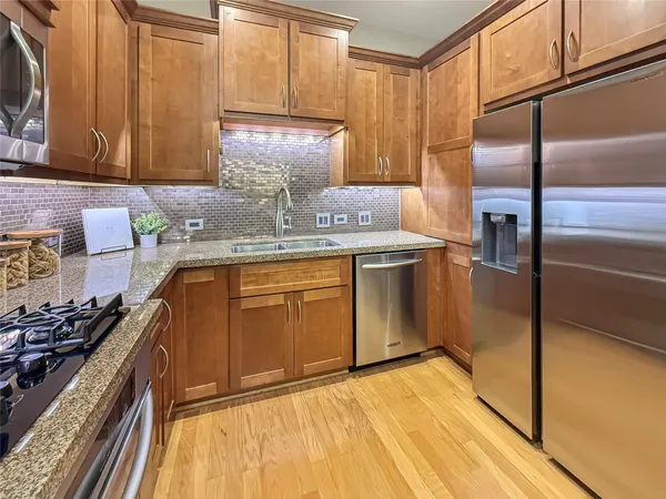 a kitchen with stainless steel appliances granite countertop a stove a sink and a refrigerator