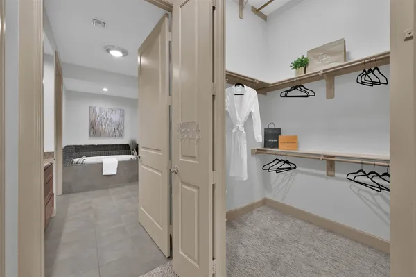 an empty room with a chandelier fan and windows