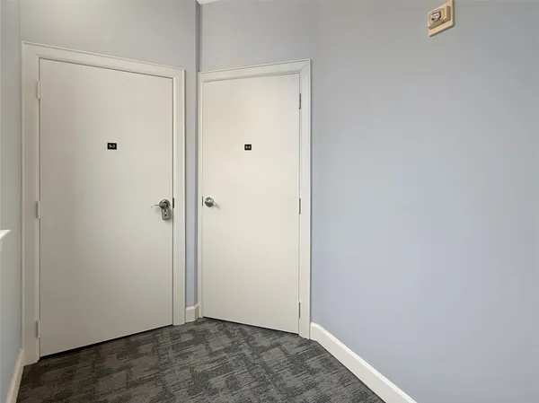 a view of a hallway with wooden floor and cabinet