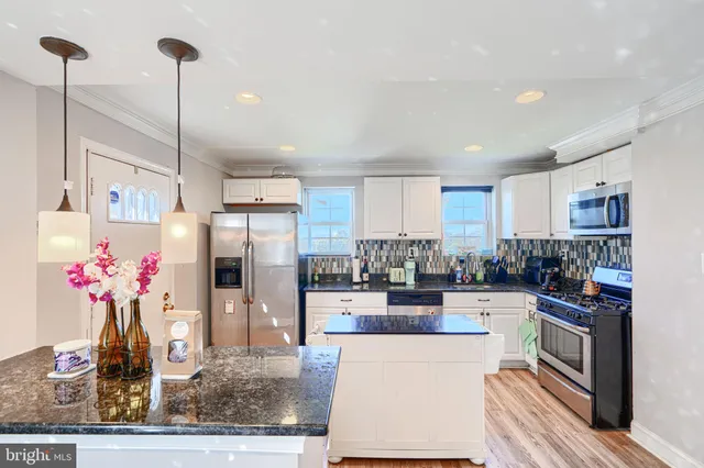 a kitchen with stainless steel appliances granite countertop a stove a sink and a refrigerator
