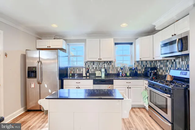 a kitchen with stainless steel appliances a stove a sink a refrigerator and cabinets