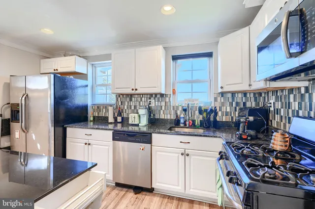 a kitchen with stainless steel appliances granite countertop a stove top oven a sink and dishwasher
