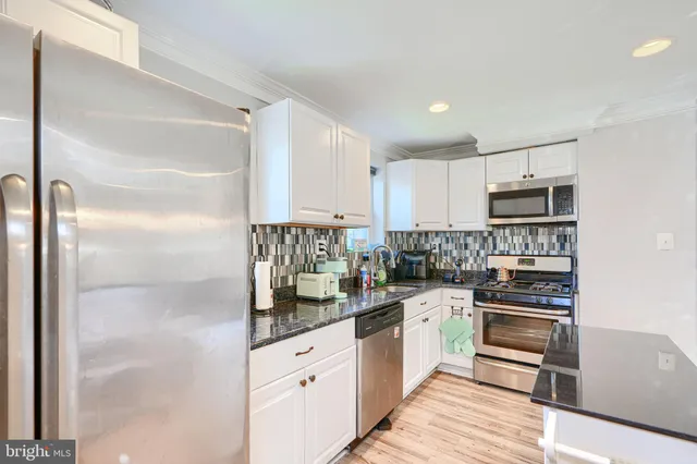 a kitchen with stainless steel appliances granite countertop a refrigerator and a sink