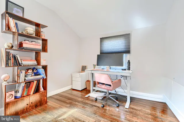 an empty room with bookshelf and wooden floor