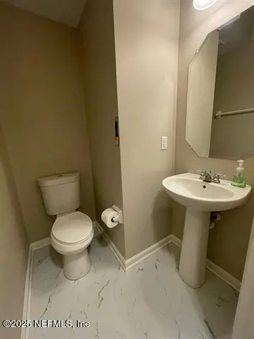a bathroom with a sink toilet and a mirror