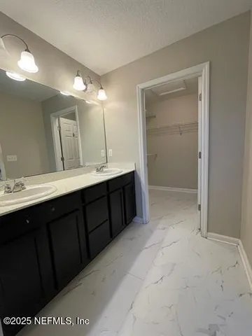 a bathroom with a double vanity sink and mirror