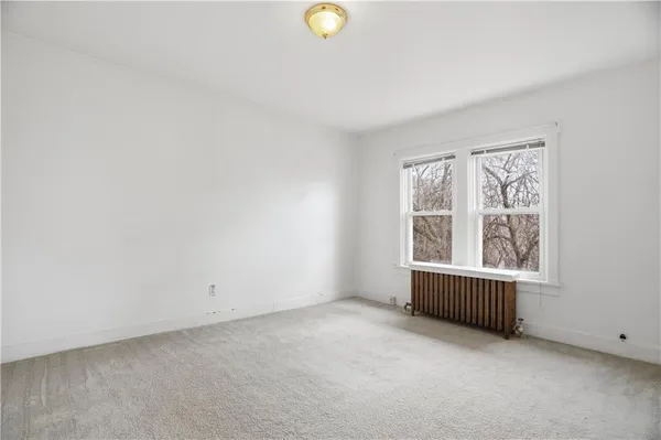 an empty room with window and mirror