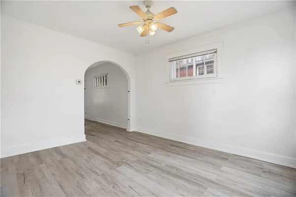 an empty room with wooden floor a ceiling fan and closet