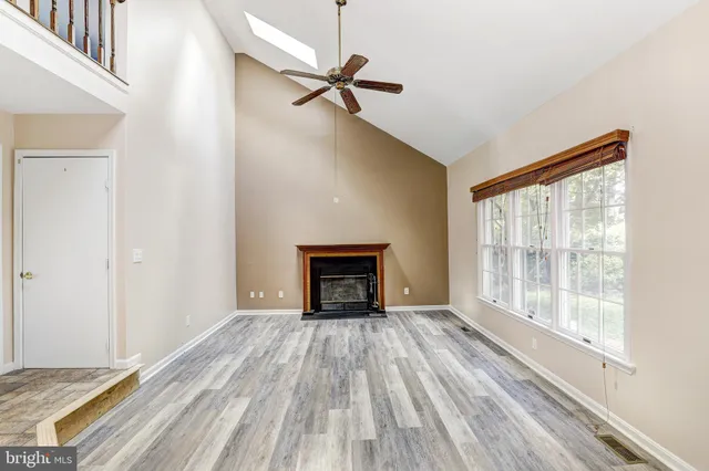 a view of an empty room with a window and fire place