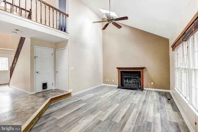 a view of an empty room with a fireplace and a window