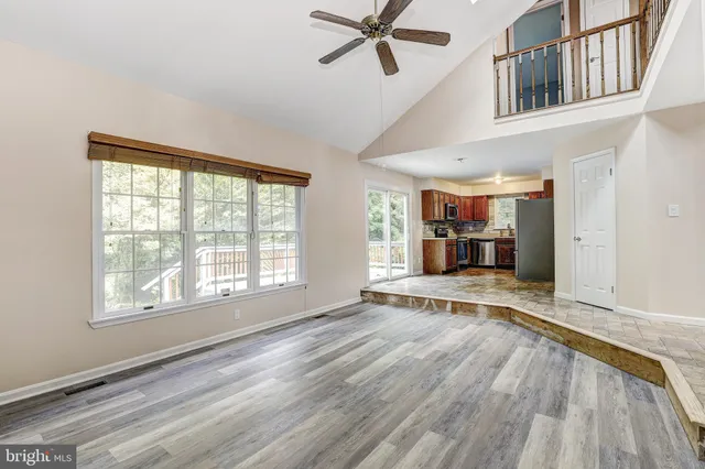a view of empty room with wooden floor and window