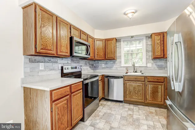 a kitchen with stainless steel appliances granite countertop a stove sink and cabinets