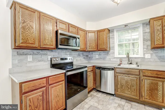 a kitchen with stainless steel appliances granite countertop a stove sink microwave and cabinets