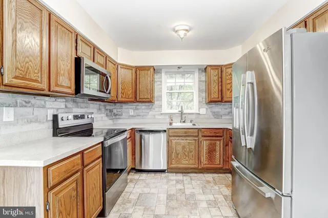 a kitchen with stainless steel appliances granite countertop a refrigerator sink and stove