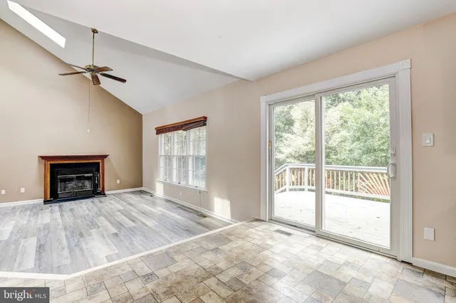 a view of an empty room with a fireplace and a window