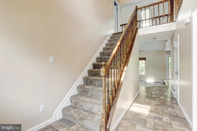 a view of staircase with lots of frames on wall and a glass door