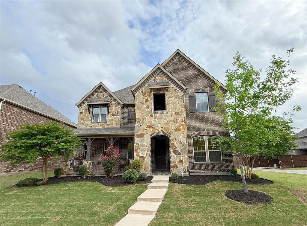 9829 Sharps Road Frisco, TX 75035 - Photo 1 of 40 French country home featuring stone siding, brick siding, a porch, and a front lawn