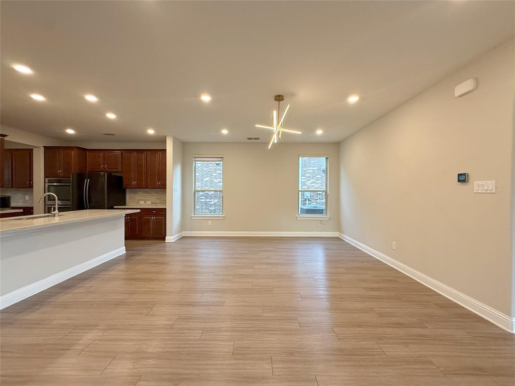 9829 Sharps Road Frisco, TX 75035 - Photo 40 of 40 Kitchen with freestanding refrigerator, open floor plan, recessed lighting, light wood-style floors, and decorative backsplash
