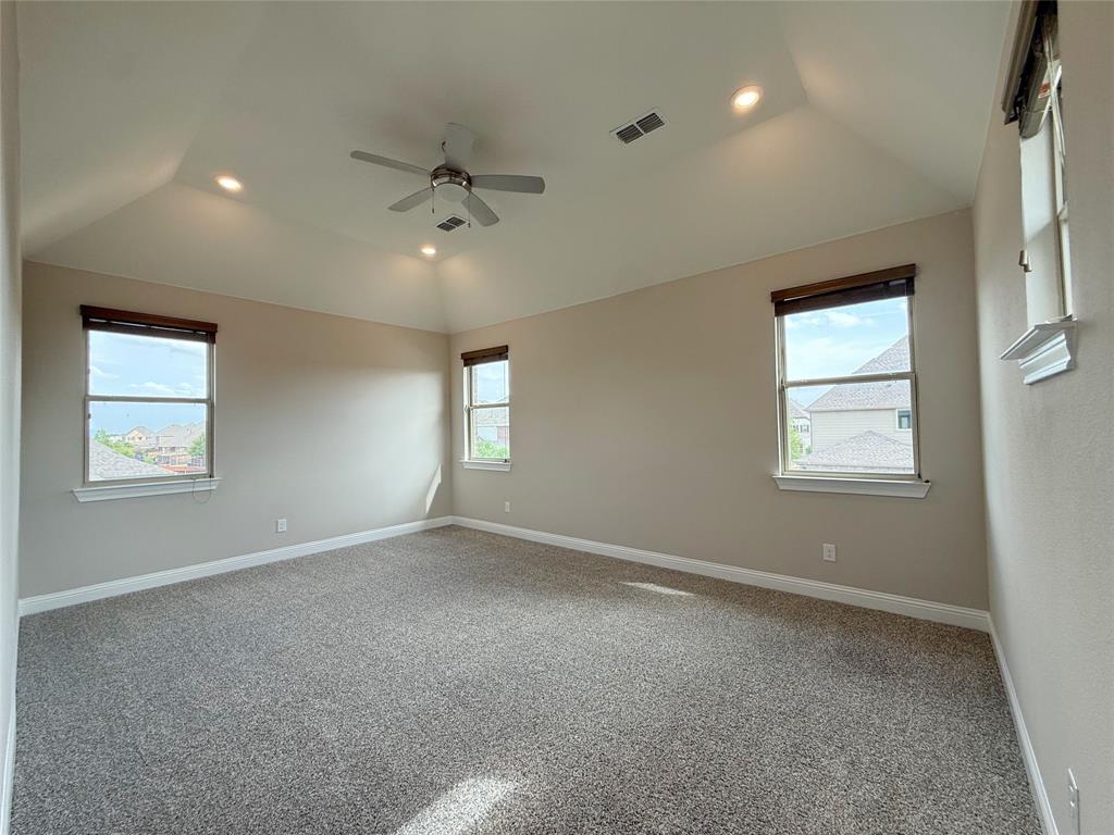 9829 Sharps Road Frisco, TX 75035 - Photo 17 of 40 Carpeted spare room featuring recessed lighting, healthy amount of natural light, ceiling fan, and lofted ceiling