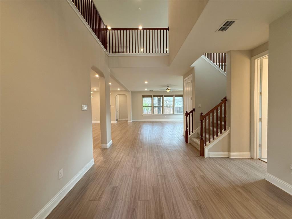 9829 Sharps Road Frisco, TX 75035 - Photo 2 of 40 Entryway featuring arched walkways, light wood finished floors, ceiling fan, recessed lighting, and a high ceiling