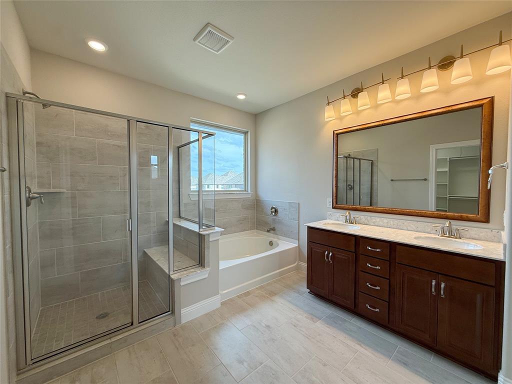 9829 Sharps Road Frisco, TX 75035 - Photo 21 of 40 Bathroom featuring double vanity, a shower stall, a bath, and recessed lighting