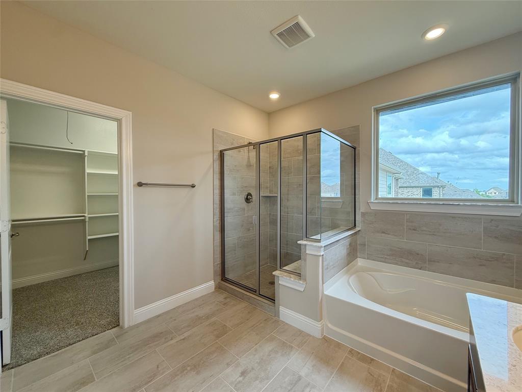 9829 Sharps Road Frisco, TX 75035 - Photo 22 of 40 Bathroom featuring a spacious closet, a stall shower, a bath, vanity, and recessed lighting
