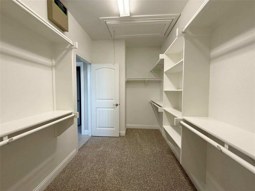 9829 Sharps Road Frisco, TX 75035 - Photo 24 of 40 Walk in closet featuring dark carpet and attic access