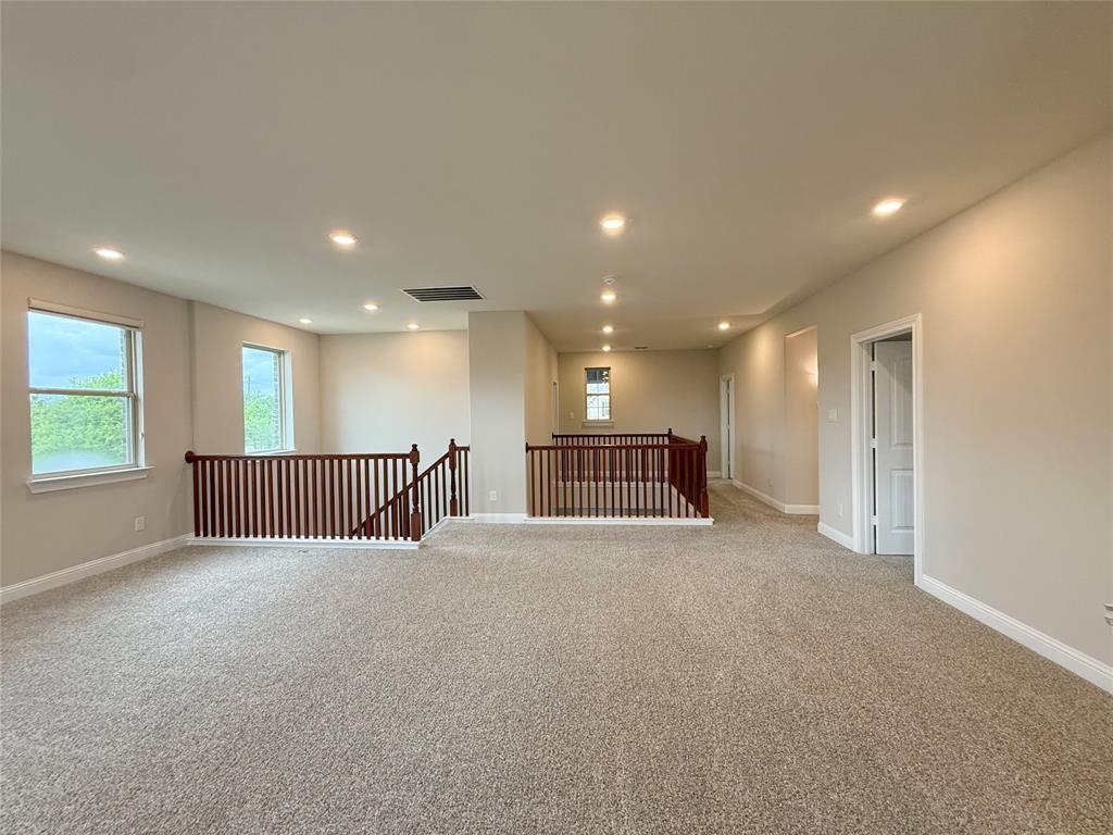 9829 Sharps Road Frisco, TX 75035 - Photo 26 of 40 Empty room with light colored carpet and recessed lighting